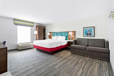 a hotel room with a bed and a couch at Hampton Inn Washington in Washington