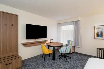 a hotel room with a table and chairs and a television at Hampton Inn Marietta in Marietta