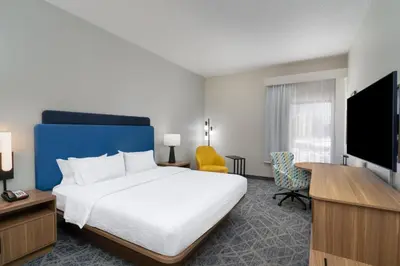 a hotel room with a bed and a flat screen tv at Hampton Inn Marietta in Marietta