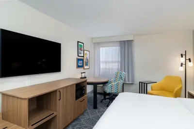 a hotel room with a bed and a flat screen tv at Hampton Inn Marietta in Marietta