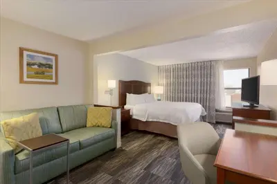 a hotel room with a bed and a couch at Hampton Inn Zanesville in Zanesville