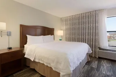 a hotel room with a large bed and a window at Hampton Inn Zanesville in Zanesville