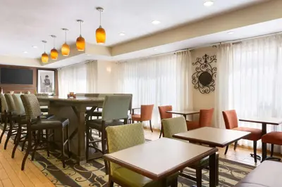 a restaurant with tables and chairs and windows at Hampton Inn Zanesville in Zanesville