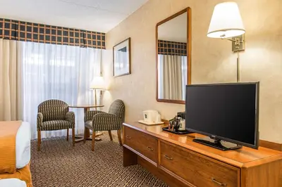 a hotel room with a flat screen tv and a bedroom at Quality Inn and Conference Center in Springfield