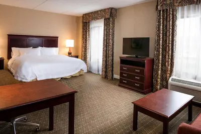 a hotel room with a bed and a television at Hampton Inn & Suites Toledo-Perrysburg in Rossford