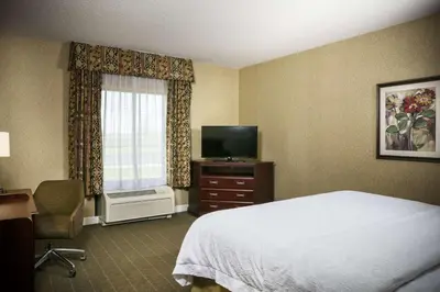 a hotel room with a bed and a television at Hampton Inn & Suites Toledo-Perrysburg in Rossford