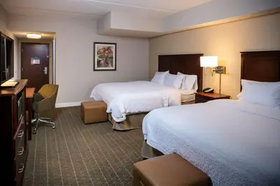 a hotel room with two beds and a desk at Hampton Inn & Suites Toledo-Perrysburg in Rossford