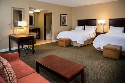 a hotel room with two beds and a couch at Hampton Inn & Suites Toledo-Perrysburg in Rossford