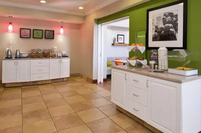 a kitchen with white cabinets and green walls at Hampton Inn & Suites Wilmington in Wilmington