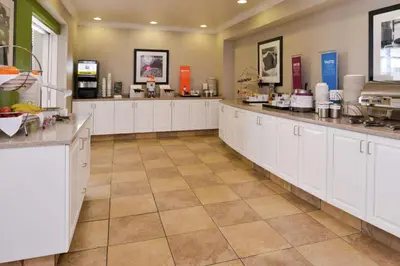 a large kitchen with white cabinets and counter tops at Hampton Inn & Suites Wilmington in Wilmington