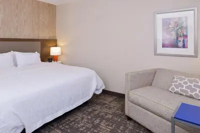 a hotel room with a bed and a couch at Hampton Inn & Suites Wilmington in Wilmington