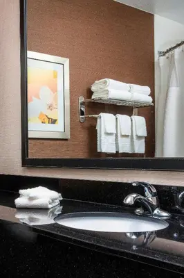 a bathroom with a sink and a mirror and towels at Fairfield Inn & Suites by Marriott Dayton South in Centerville