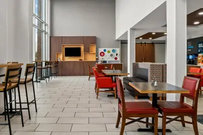 a restaurant with tables and chairs and a kitchen at Holiday Inn Express Hotel & Suites Marion by IHG in Marion