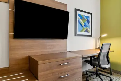 a room with a desk and a television on a wall at Holiday Inn Express Hotel & Suites Marion by IHG in Marion