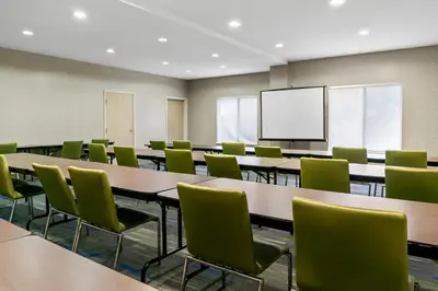 an empty classroom with tables and chairs and a screen at Holiday Inn Express Hotel & Suites Marion by IHG in Marion