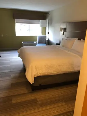 a hotel room with a large bed and a chair at Holiday Inn Express Mt. Vernon by IHG in Mount Vernon