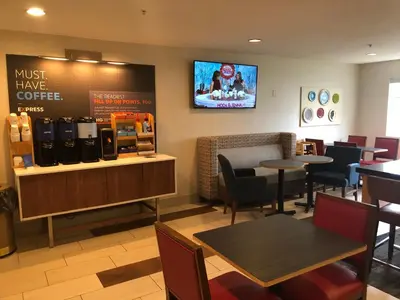 a restaurant with tables and chairs and a tv on the wall at Holiday Inn Express Mt. Vernon by IHG in Mount Vernon