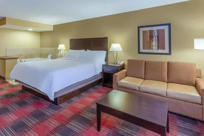 a hotel room with a bed and a couch at Holiday Inn Express Hotel & Suites Bowling Green by IHG in Bowling Green