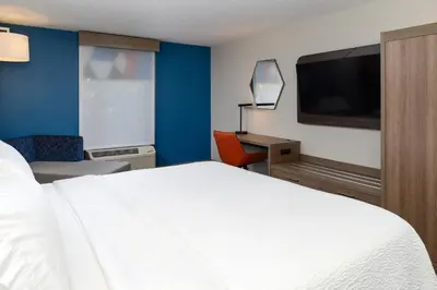 a hotel room with a bed and a desk and a tv at Holiday Inn Express Hotel and Suites Marysville by IHG in Marysville