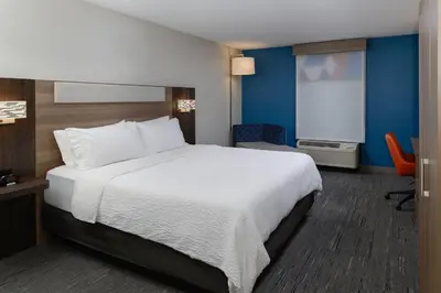 a hotel room with a large bed and a chair at Holiday Inn Express Hotel and Suites Marysville by IHG in Marysville