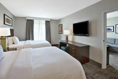 a hotel room with two beds and a flat screen tv at Embassy Suites Columbus - Airport in Columbus