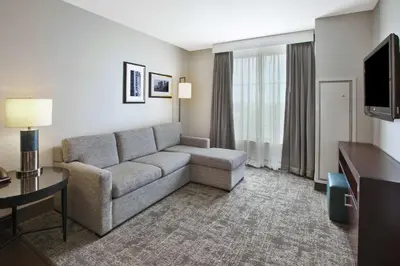 a living room with a couch and a television at Embassy Suites Columbus - Airport in Columbus