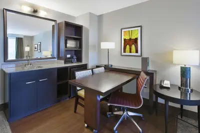 a room with a desk and a sink and a table at Embassy Suites Columbus - Airport in Columbus