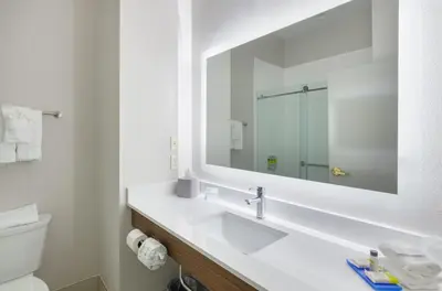 a white bathroom with a sink and a mirror at Holiday Inn Express Hotel & Suites Weston by IHG in Weston