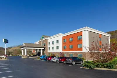 a parking lot with cars parked in front of a building at Holiday Inn Express Hotel & Suites Weston by IHG in Weston