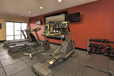a gym with several tread machines and a mirror at Hampton Inn Defiance in Defiance