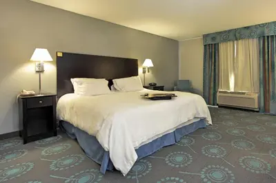 a hotel room with a large bed and a window at Hampton Inn Defiance in Defiance
