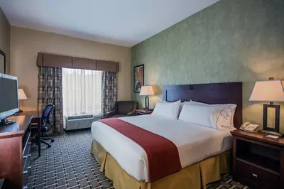 a hotel room with a large bed and a desk at Holiday Inn Express Hotel & Suites Youngstown North-Warren/Niles by IHG in Warren