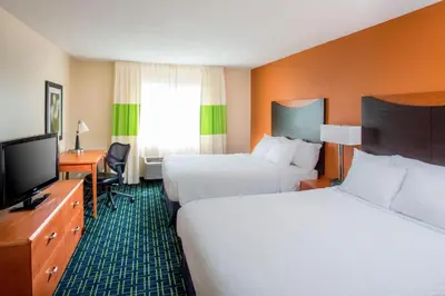 a hotel room with two beds and a flat screen tv at Fairfield Inn Middletown Monroe in Middletown