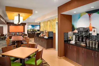 a restaurant with tables and chairs and a coffee shop at Fairfield Inn & Suites Lima in Lima