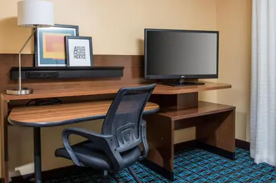 a desk with a monitor and a chair in a hotel room at Fairfield Inn & Suites Ashland in Ashland