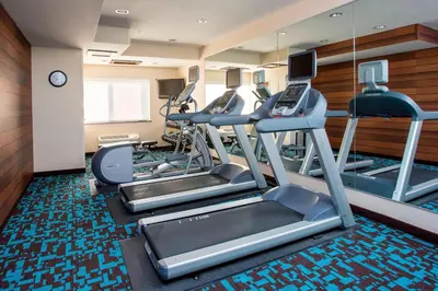 a gym with treadmills and ellipticals in a room at Fairfield Inn & Suites Ashland in Ashland