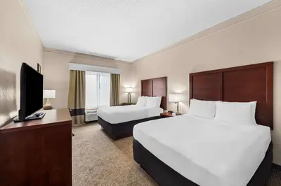 a hotel room with two beds and a flat screen tv at Comfort Inn & Suites Heath - Newark South in Heath