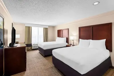 a hotel room with two beds and a flat screen tv at Comfort Inn & Suites Heath - Newark South in Heath