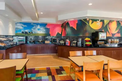 a restaurant with two tables and a counter with a kitchen at Fairfield Inn & Suites Mansfield Ontario in Mansfield