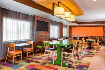 a dining room with a green table and chairs at Fairfield Inn & Suites Mansfield Ontario in Mansfield
