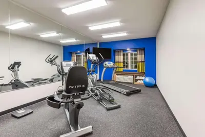 a gym with several tread machines and a mirror at Microtel Inn & Suites by Wyndham New Martinsville in New Martinsville