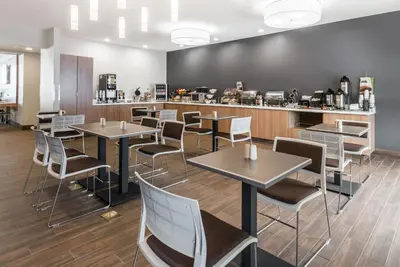 a restaurant with tables and chairs and a counter at Microtel Inn & Suites by Wyndham New Martinsville in New Martinsville