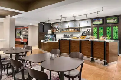 a restaurant with tables and chairs and a kitchen at Courtyard by Marriott Dayton North in Dayton