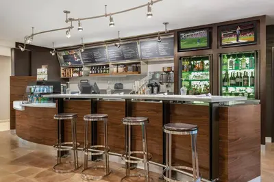 a bar in a restaurant with stools at Courtyard by Marriott Dayton North in Dayton