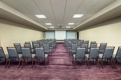 an empty room with chairs and a white screen at Courtyard by Marriott Dayton North in Dayton