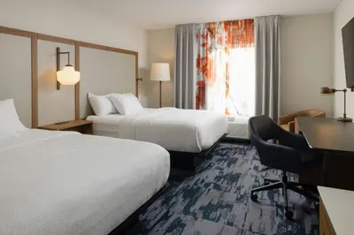 a hotel room with two beds and a desk at Fairfield Inn and Suites by Marriott Fort Wayne in Fort Wayne