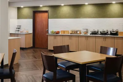 a restaurant with a table and chairs and a kitchen at Fairfield Inn and Suites by Marriott Fort Wayne in Fort Wayne
