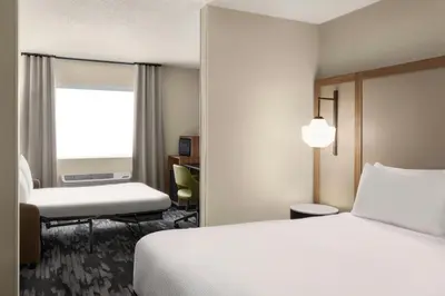 a hotel room with a bed and a chair at Fairfield Inn & Suites Findlay in Findlay