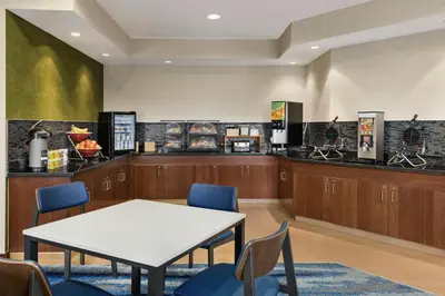a waiting room with a table and chairs and a counter at Fairfield Inn & Suites Findlay in Findlay