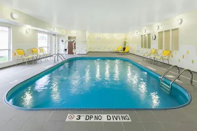 a large pool in a room with chairs and tables at Fairfield Inn & Suites Findlay in Findlay